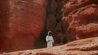 photography of astronaut standing beside rock formation during daytime by Nicolas Lobos courtesy of Unsplash.