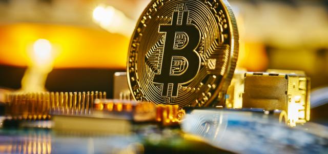 a bitcoin sitting on top of a computer chip by Michael Förtsch courtesy of Unsplash.
